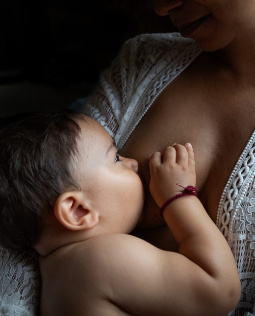 Photographie artistique d’une maman allaitant son bébé, moment de tendresse et de connexion – séance photo allaitement haut de gamme à Paris, Bordeaux et Aix-en-Provence.